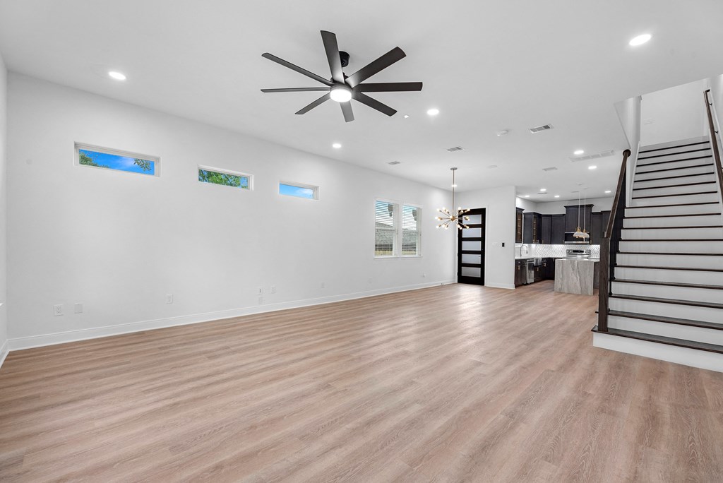 a living room with a staircase and a ceiling fan
