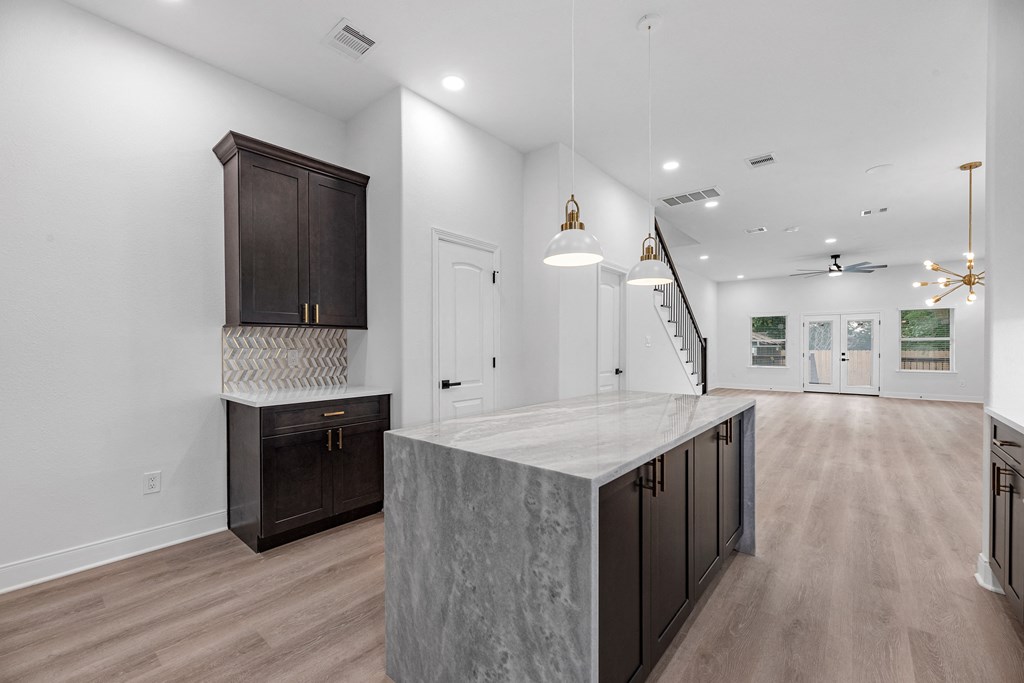 a kitchen with a large island and a staircase in a house