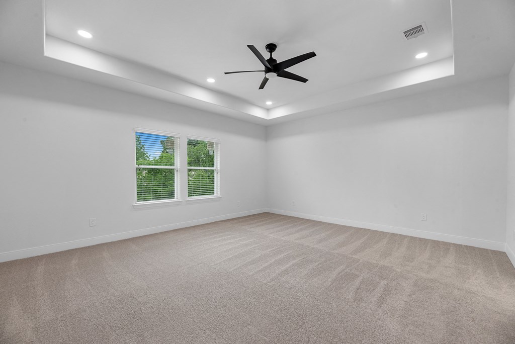 an empty living room with a ceiling fan and a window