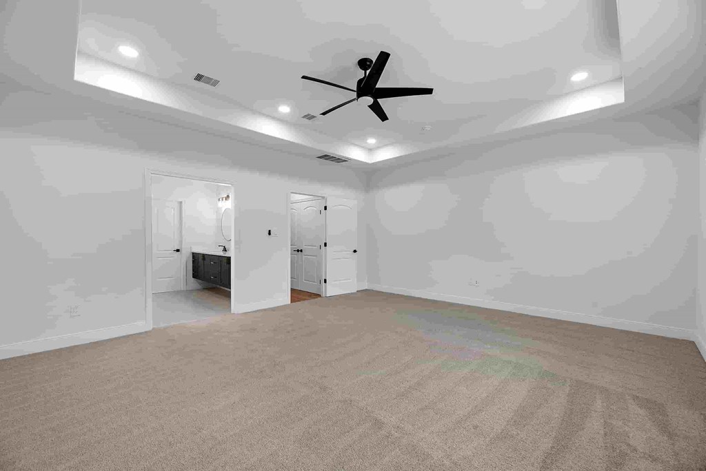 an empty living room with a ceiling fan