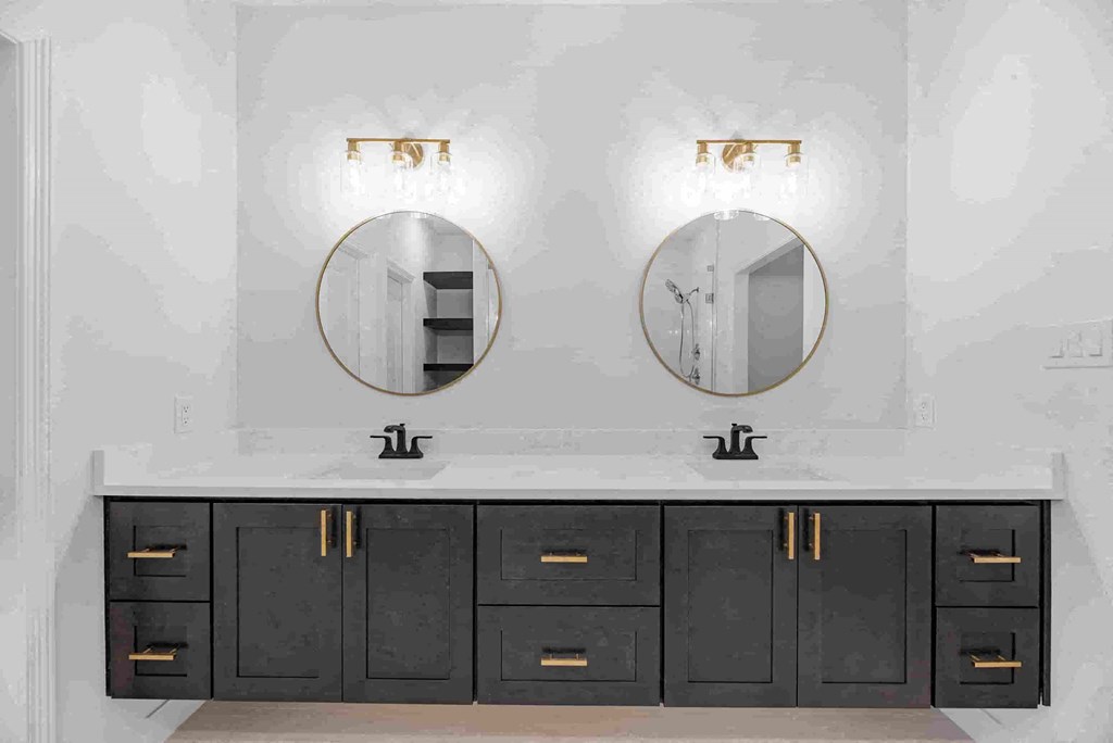 a bathroom with two sinks and two mirrors