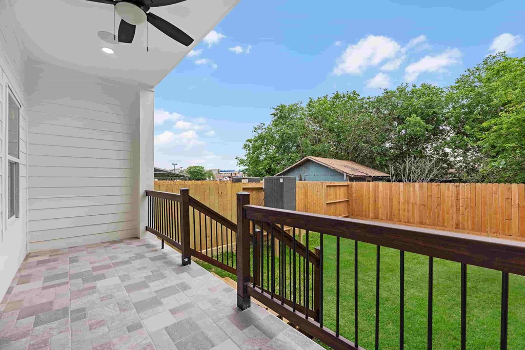 a backyard with a wooden fence and a porch