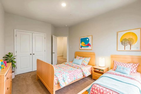 A bedroom with two beds and a dresser.