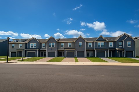 A row of houses with grey roofs and blue walls.
