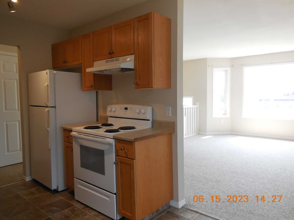 an empty kitchen with a stove refrigerator and