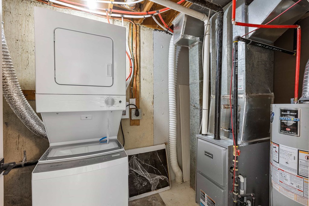 a white refrigerator freezer sitting in a room next to a water heater