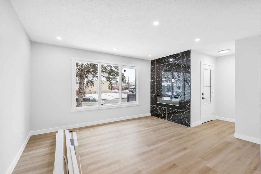 a living room with white walls and a large window and a glass closet