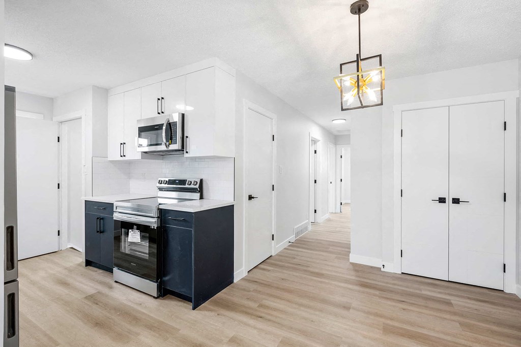 a kitchen with white cabinets and a stove and a microwave