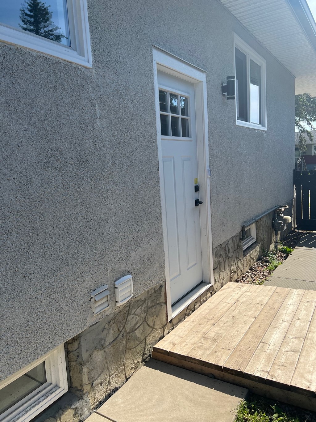 a house with a white door and a wooden deck