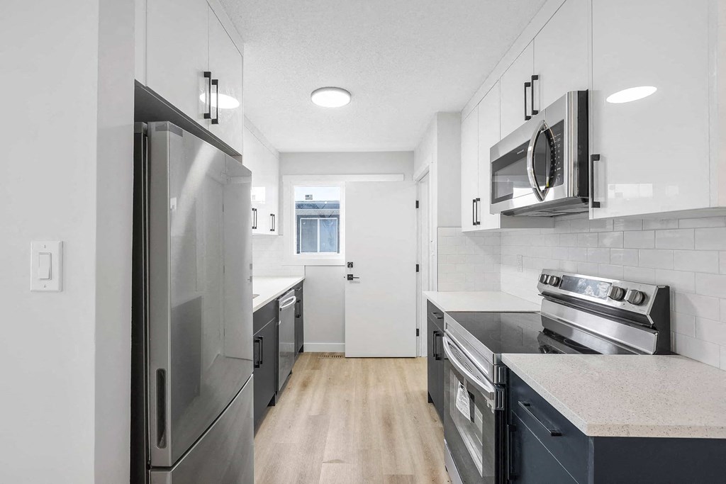 a kitchen with stainless steel appliances and white cabinets
