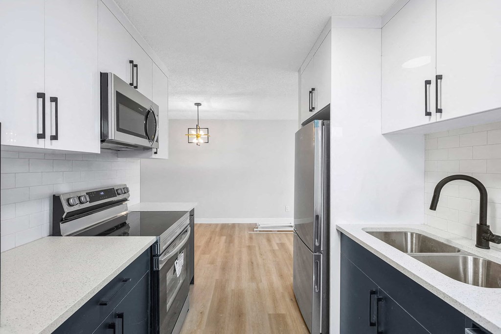 a kitchen with stainless steel appliances and white cabinets