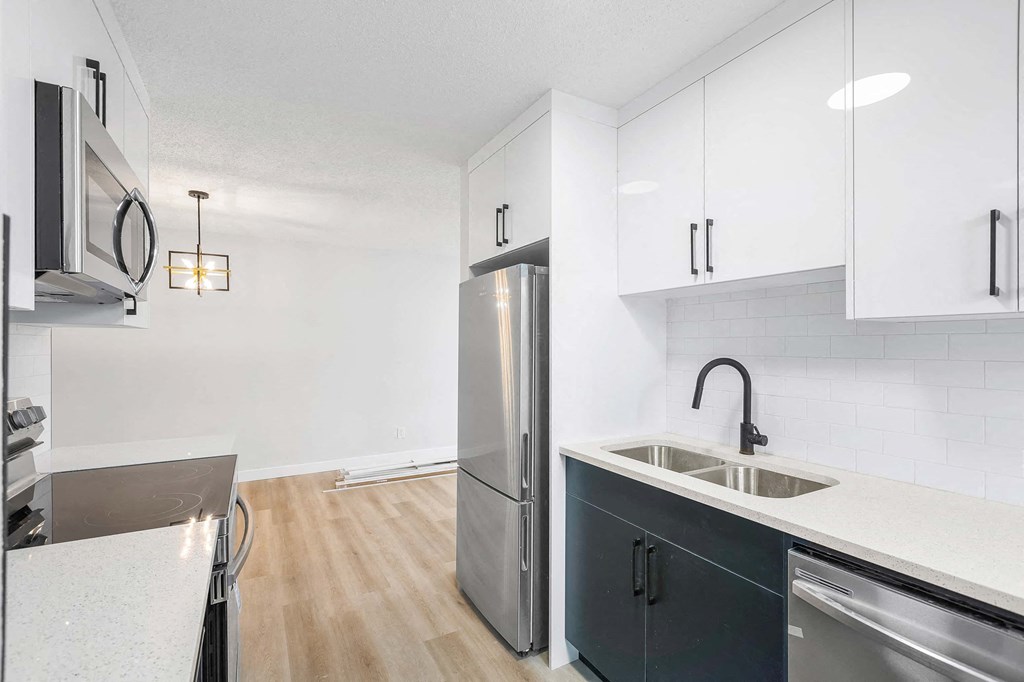 a kitchen with white cabinets and a stainless steel refrigerator