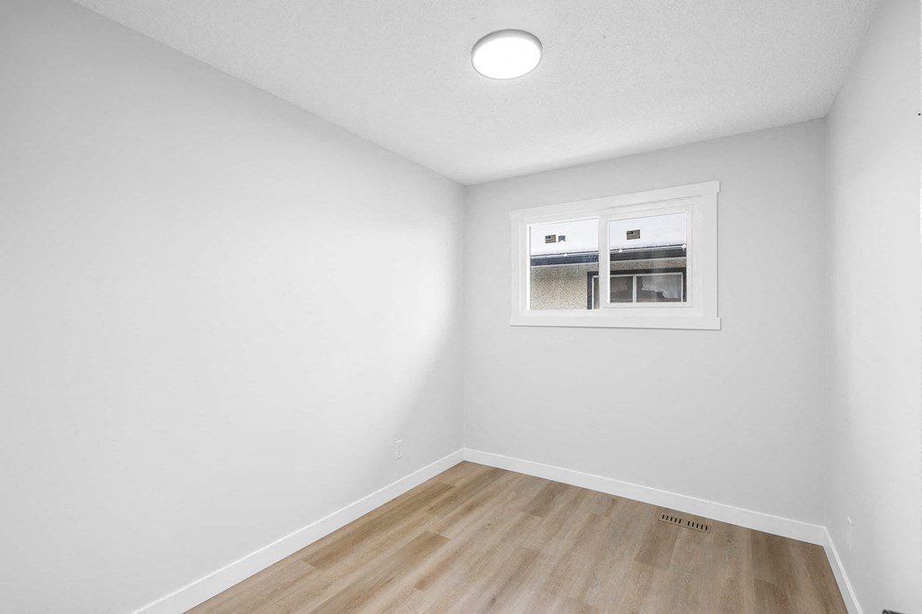 a living room with white walls and a window