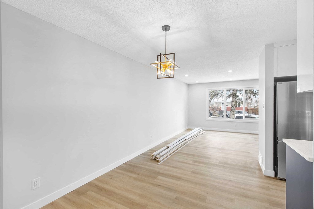 a kitchen and dining room with white walls and a window
