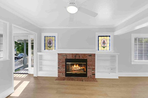 A living room with a fireplace and stained glass windows.