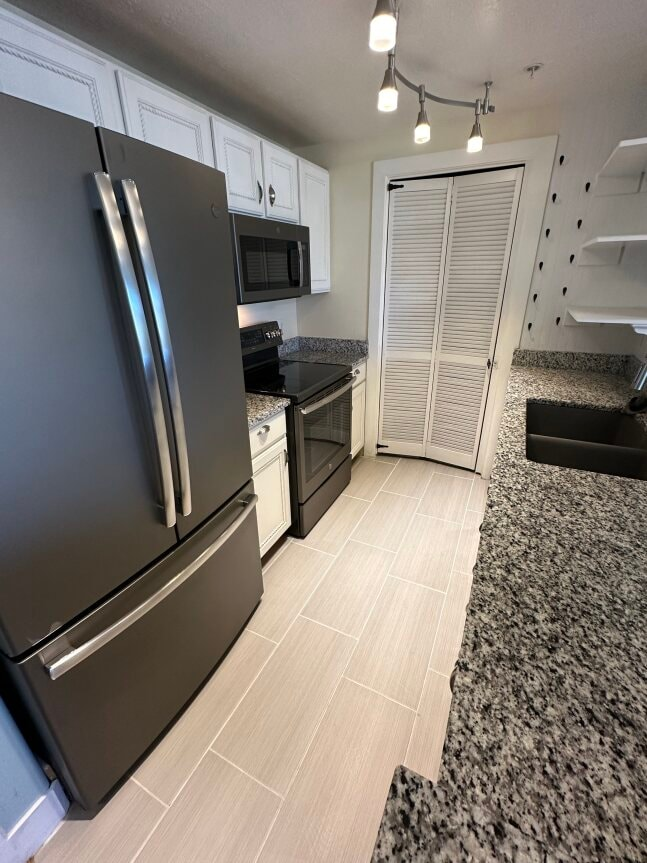 a kitchen with a stainless steel refrigerator and a sink