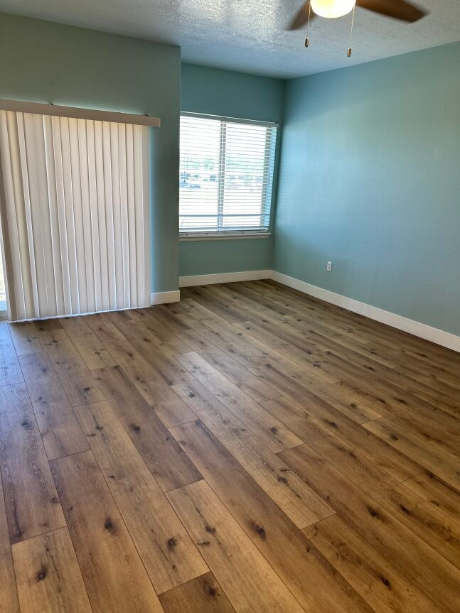 an empty living room with wood flooring and a closet
