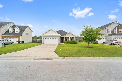 a neighborhood of houses on a street with a driveway and lawn