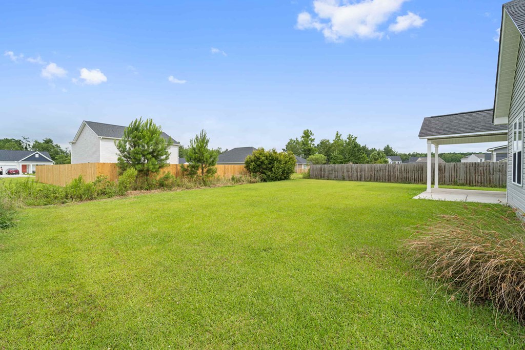 the backyard of a house with a lawn and a fence