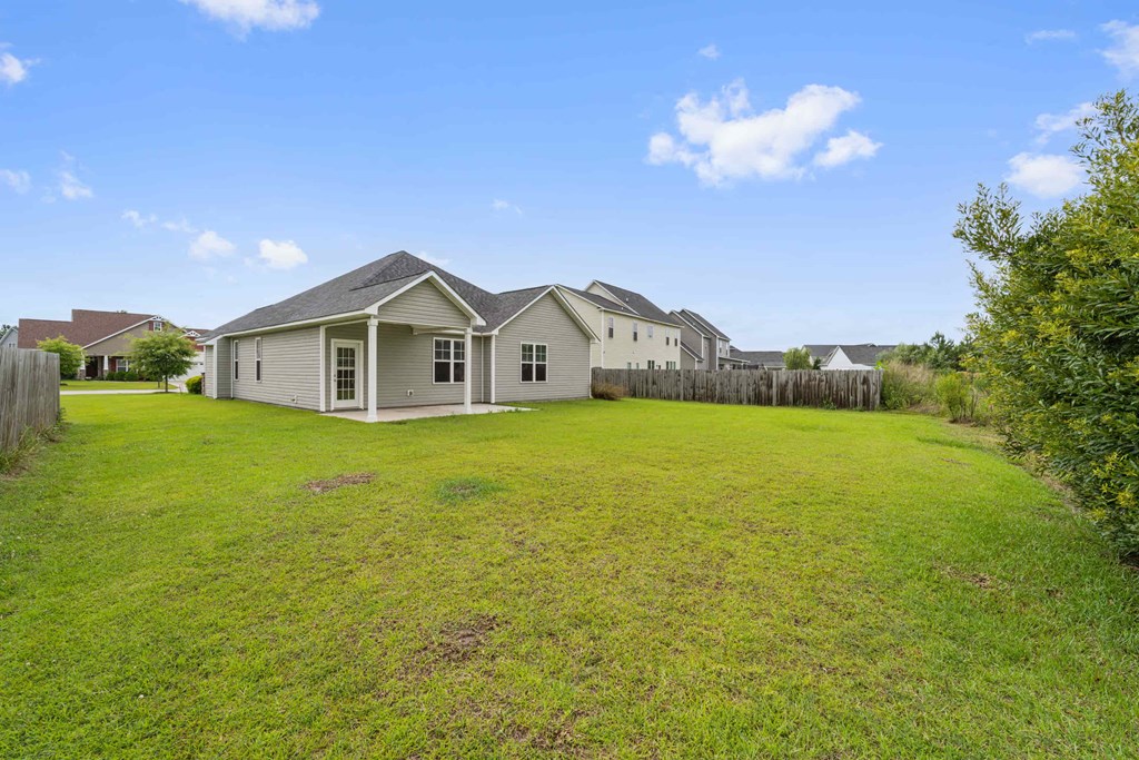 a group of houses in a large grassy field