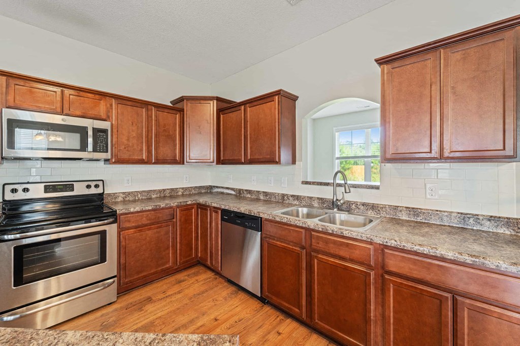 a kitchen with wooden cabinets and stainless steel appliances