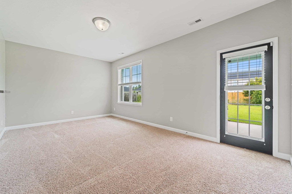 an empty living room with a door to a patio