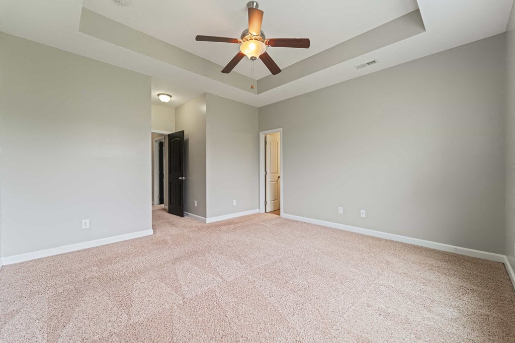 an empty living room with a ceiling fan