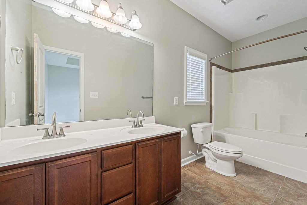 a bathroom with a large mirror and a toilet and a sink