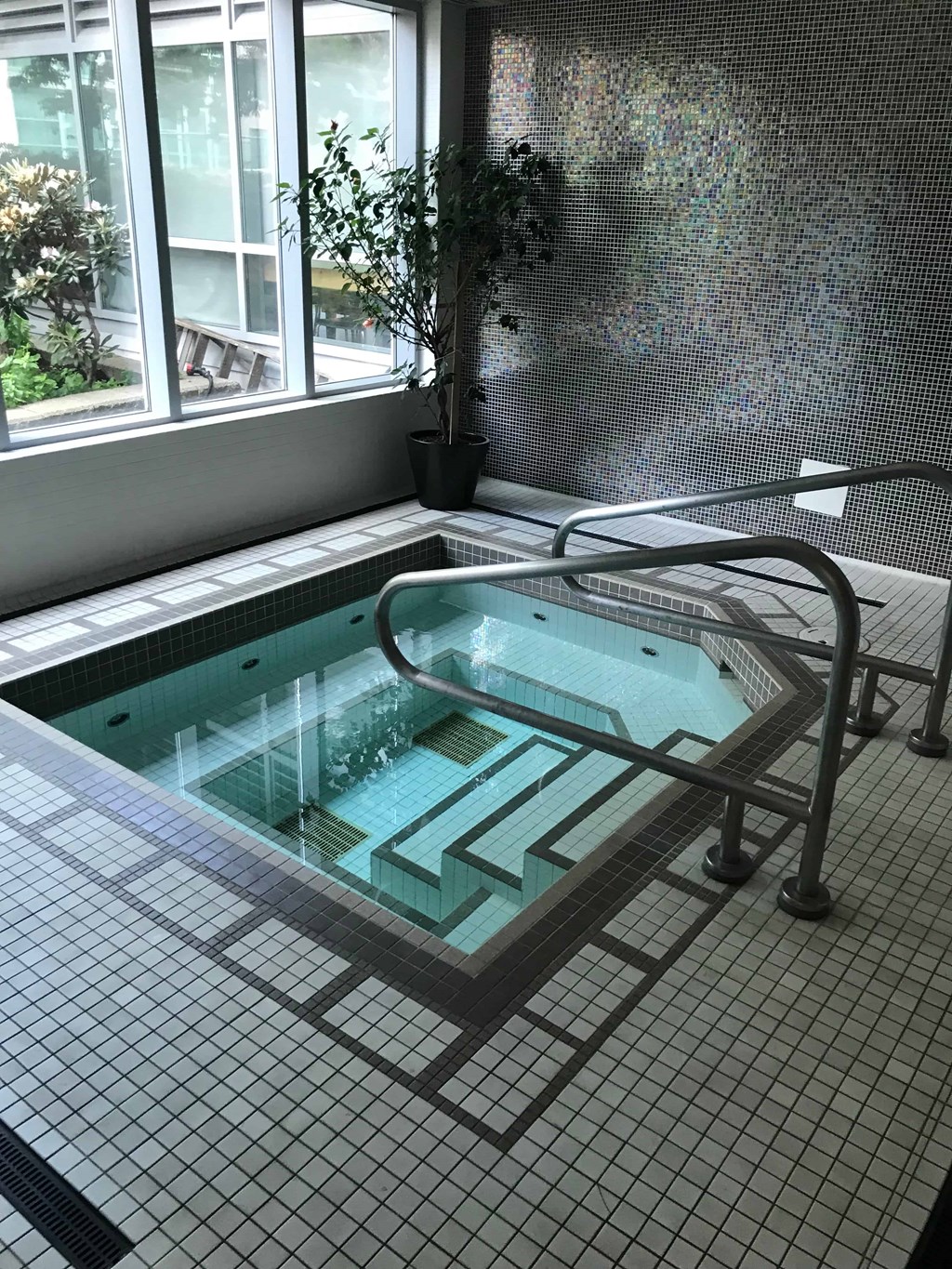 a jacuzzi in a room with a table and a chair