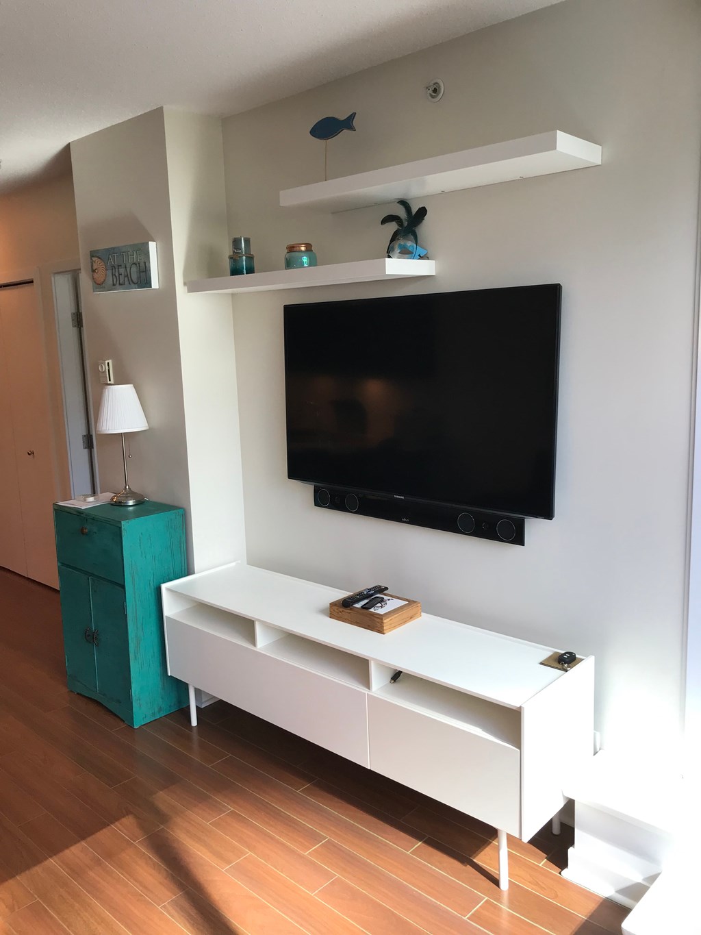a living room with a tv and a white entertainment center