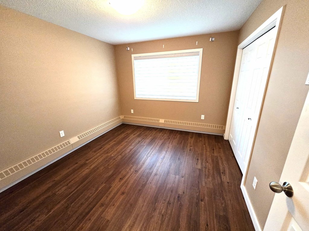 a empty room with wooden floors and a window