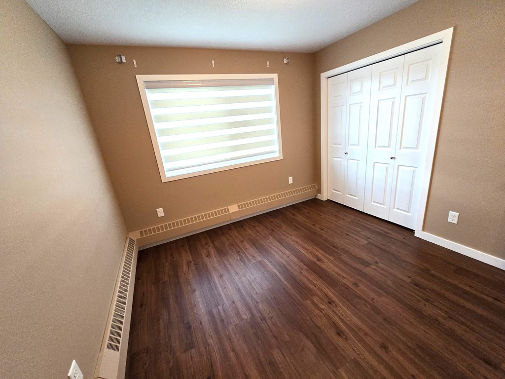 a empty room with wooden floors and a window and a door