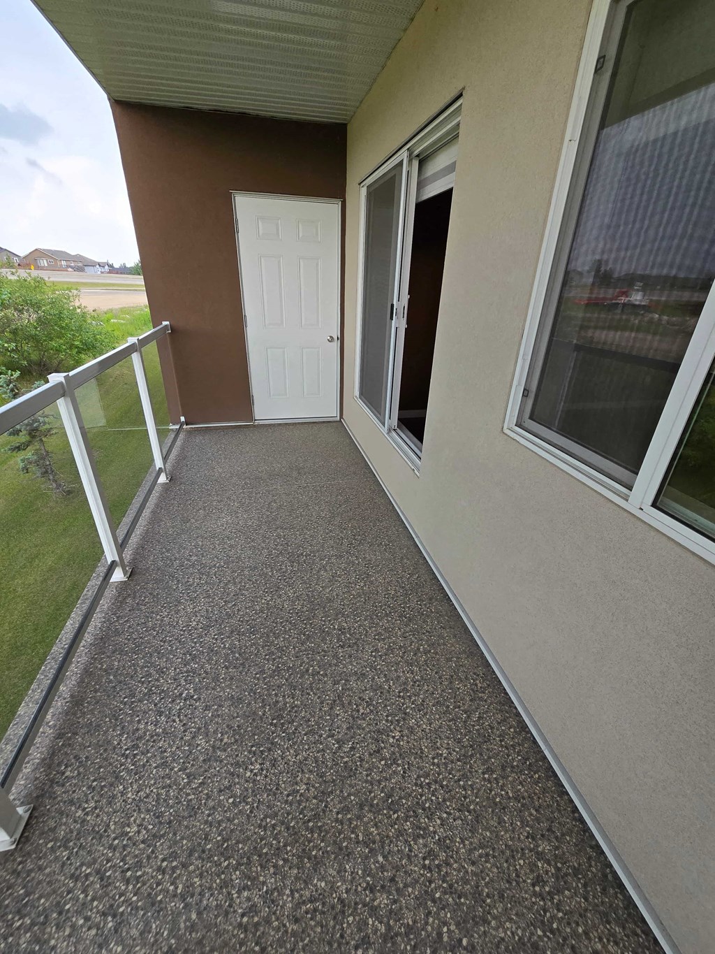 a covered porch with a white door and a balcony