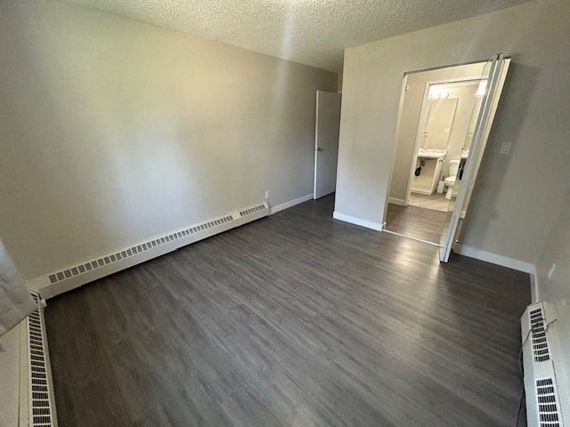 an empty living room with wood flooring and a door to a bathroom