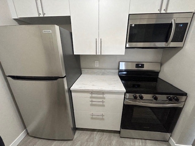 a kitchen with stainless steel appliances and white cabinets