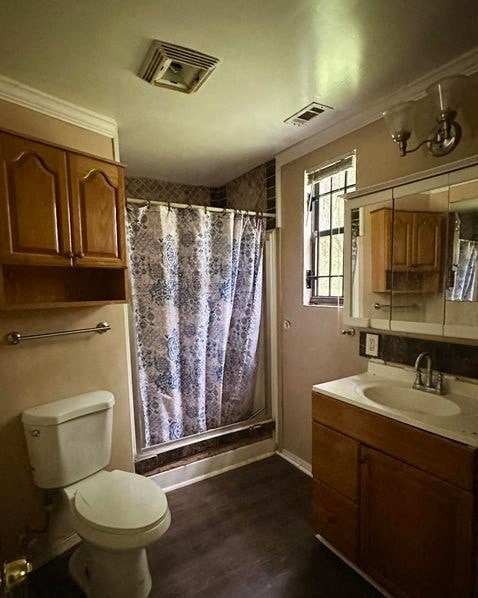 a bathroom with a shower and a toilet and a sink