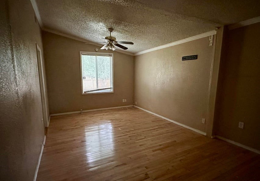 a empty living room with a ceiling fan