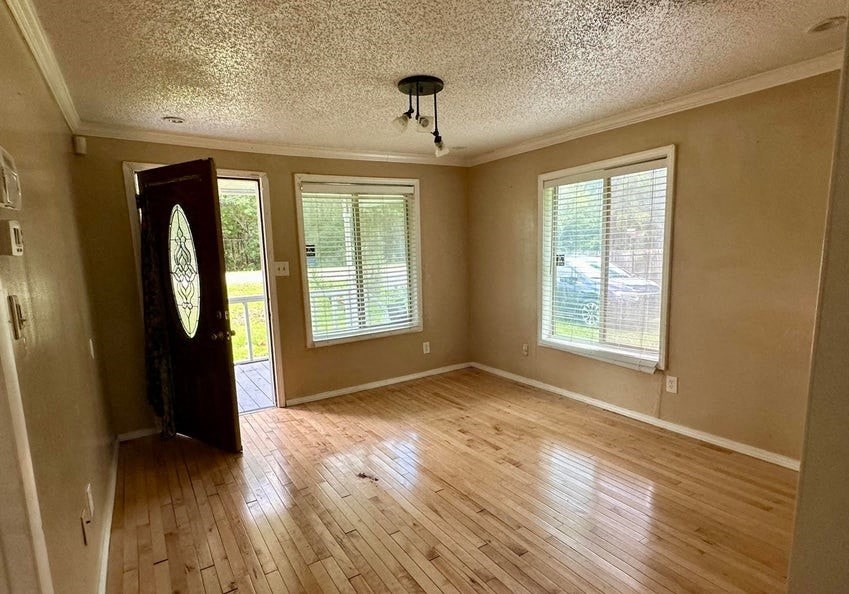 an empty living room with a hard wood floor