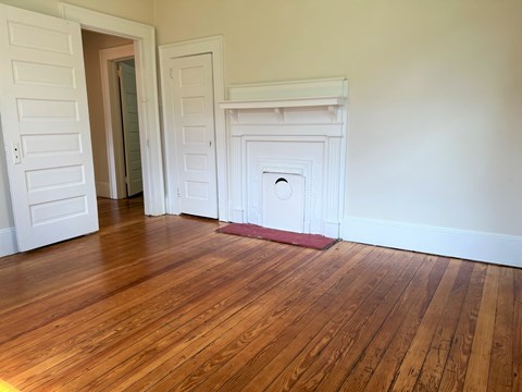 a living room with wood floors and a door to a closet