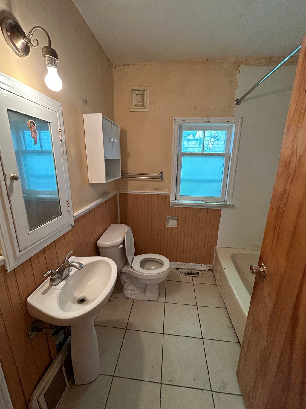 a bathroom with a toilet and a sink and a tub