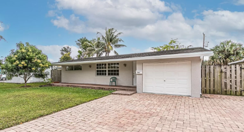 A house with a white garage door and a brick driveway.