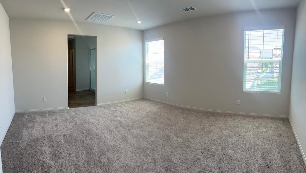 an empty living room with a carpeted floor and a window
