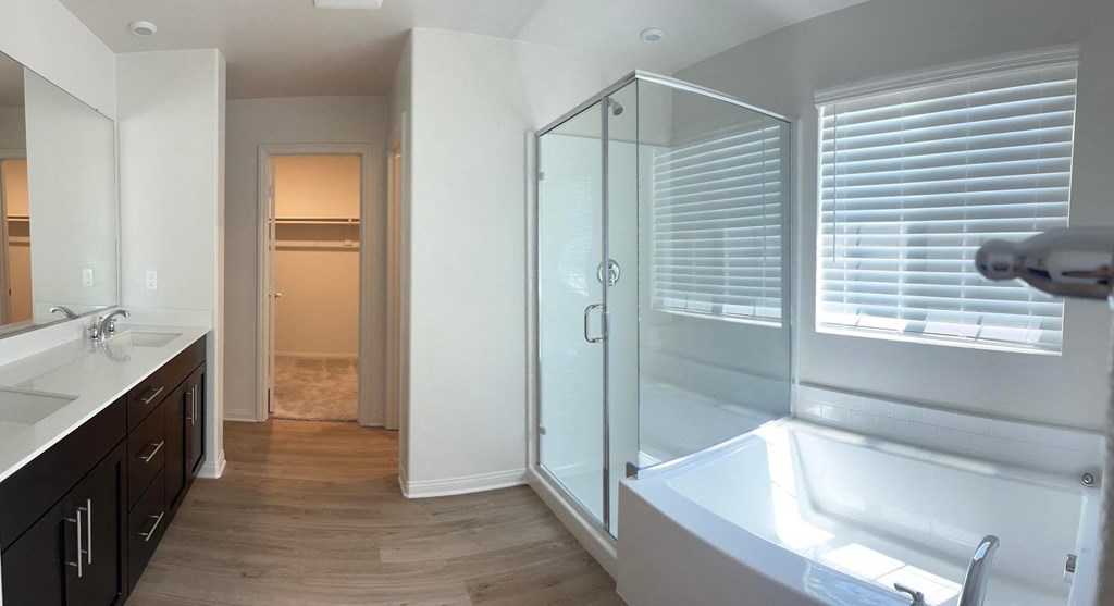 a bathroom with a tub and a shower and a sink