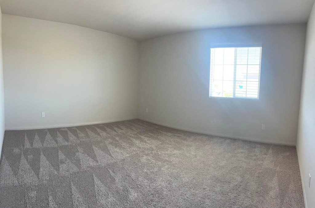 an empty room with carpet and a window