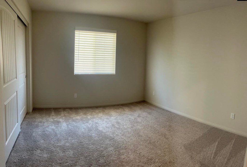 a empty room with a window and carpet