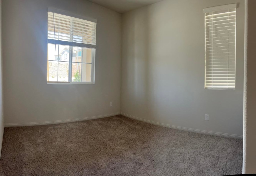 an empty room with a window and carpet