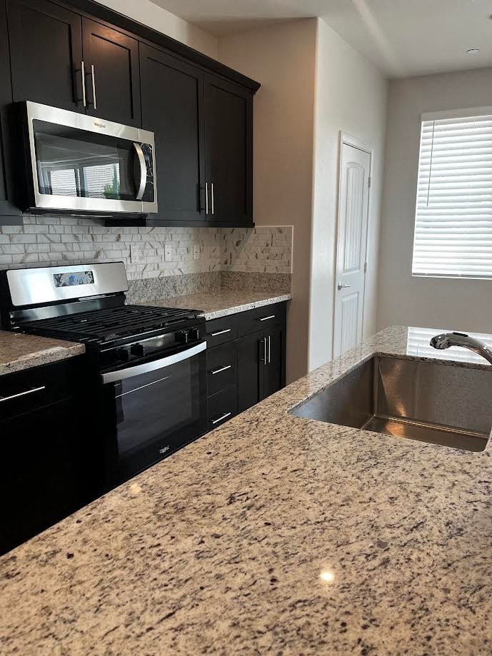 a kitchen with granite counter tops and black appliances