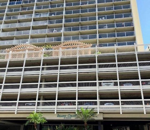 A large building with a balcony and a sign that says Island Colony.