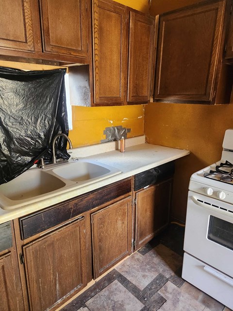 a kitchen with a sink and stove and a plastic bag on the counter