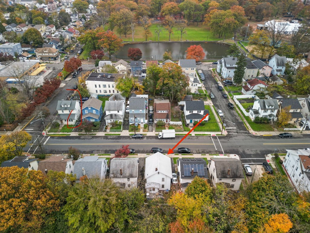 an aerial view of a neighborhood with a red arrow pinpointing a house